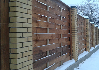 деревянный забор с кирпичными столбами 